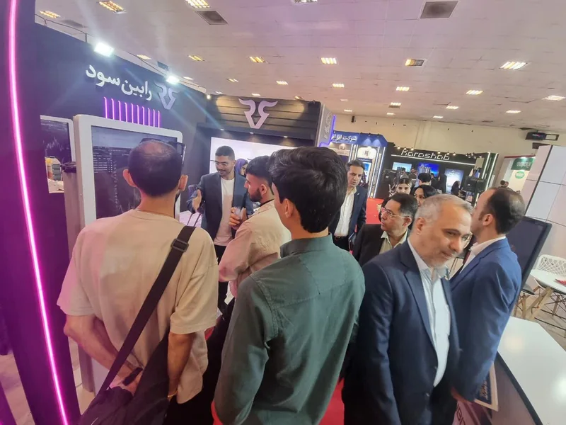 بازدیدکنندگان جلوی نمایشگرهای غرفه رابینسود در نمایشگاه تراکنش ایران ۱۴۰۴